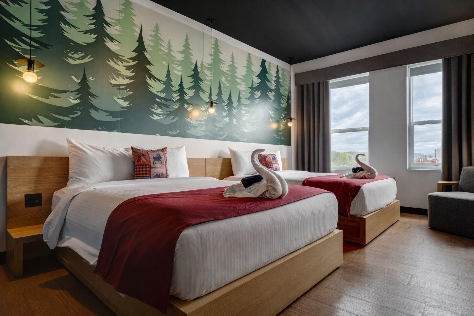 A hotel room with two beds, a mural of trees, a view of the city, and a swan decoration on the beds.