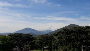 A mountainous landscape with a clear sky and dense foliage in the foreground. - Hotel Lans (Kandy)