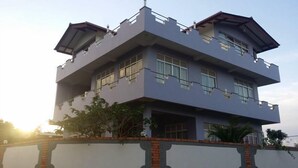 A multi-story building with a flat roof, large windows, and a stone base. - Hotel Lans (Kandy)