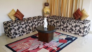 A living room with a patterned sofa set, a central coffee table, and a decorative vase. - Hotel Lans (Kandy)