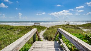 A wooden boardwalk leading to a beach with a wooden bench at the end. - RIVERFRONT community in COCOA BEACH with short walk to the beach!! (Cocoa Beach)