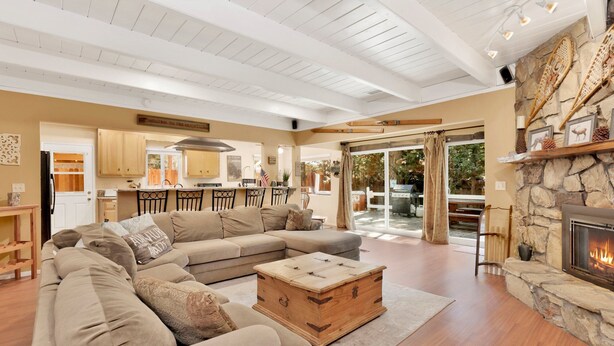 A spacious living room with a large sectional sofa, a wooden chest of drawers, and a stone fireplace. - Cozy UP TO Summit #1651 (Big Bear Lake)