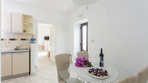 A modern kitchen with a dining area. - Apartments Maria Koločep - Two Bedroom Apartment with Terrace and Garden View (Kolocep)
