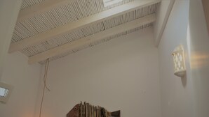 Ein Zimmer mit schrägem Dach, einer Wandleuchte und einer fischförmigen Dekoration.