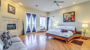 A spacious bedroom with a large bed, a sofa, and a fireplace.