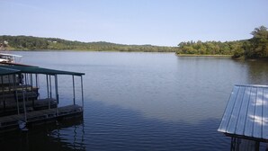 A calm lake with docked boats and a covered structure. - Great Hunting, Fishing  and Family Vacation Getaway (Linden)
