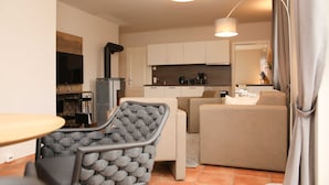 A compact living space with a kitchenette, a sofa, a dining table, and a chair. - Apartment 3 - Apartment near the beach (Nienhagen)