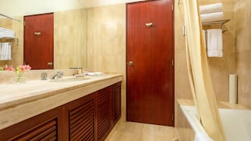 A modern bathroom with a wooden vanity, a large mirror, and a bathtub.