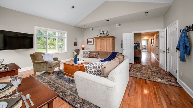 A spacious living room with a large TV, a wooden coffee table, and a sofa with patterned cushions. - Spacious Suite on Oregon Equestrian Estate (Tualatin)