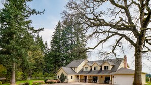 A two-story house with a garage, surrounded by trees and a well-maintained lawn. - Spacious Suite on Oregon Equestrian Estate (Tualatin)