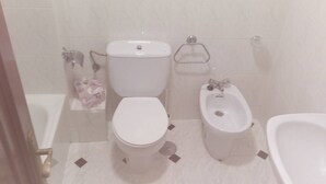 Un bagno con servizi igienici, bidet e vasca da bagno.