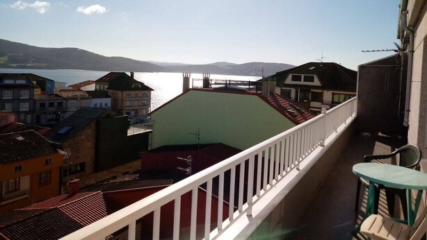 Un balcone con vista su un corpo d'acqua ed edifici.