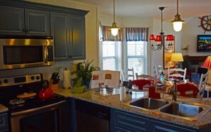 Enjoy a fully equipped kitchen with a microwave, stove, and double sink, perfect for preparing meals. The dining area offers a table and chairs.