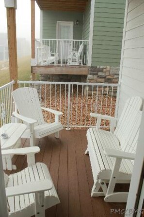 Relax on the covered porch with two Adirondack chairs and a small table.