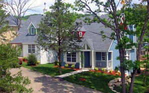 Traditional home with a gabled roof and chimney, set amidst a well-maintained lawn.