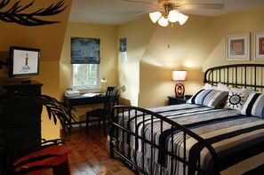 Cozy retreat with a nautical twist, featuring a neatly made bed, desk, and comfortable chair.