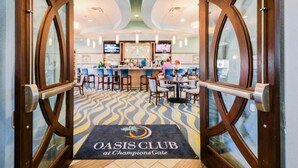 A hotel lobby with a bar area, a patterned carpet, and a sign reading "OASIS CLUB at Champions Gate". - Piece of Heaven Pool Home by AV Dreams (Davenport)