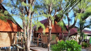 Un chalet rustique avec des cabanes en bois, un sentier en pierre et une végétation luxuriante.