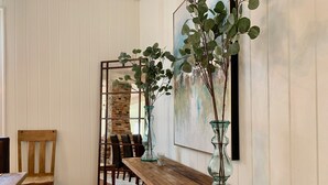 A wooden bench with two glass vases containing green plants, a wooden chair, and a brick wall with a metal gate in the background. - The RED DOOR: Explore Pensacola's Downtown Entertainment next to Wedding Venues! (Pensacola)
