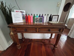 Una mesa de madera con botellas de agua de metal y un cuadro enmarcado encima.