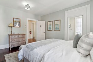 Un dormitorio con cama, cómoda y cuadros en la pared.