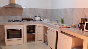 A modern kitchen with a built-in oven, a stove, a microwave, and a coffee maker.