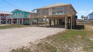 A beachfront hotel with a wooden deck, a covered area, and a clear sky. - Spacious house within walking distance from beach- less then 100 yards (Gulf Shores)