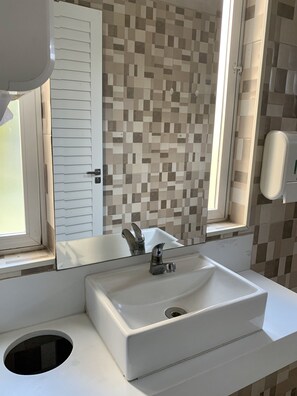 Een douche, handdoeken, zeep, toiletpapier