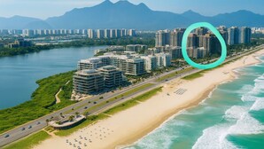 Paesaggio costiero con edifici alti, una spiaggia e una strada che porta alla spiaggia.