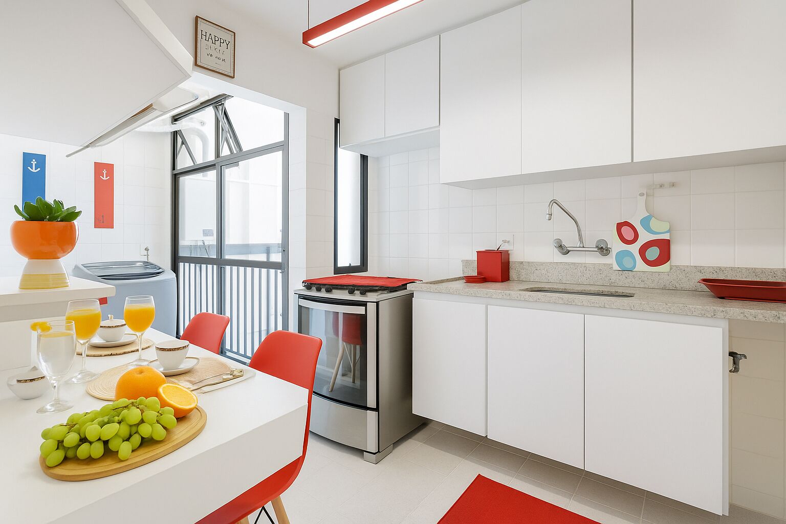Une cuisine moderne avec des armoires blanches, une cuisinière en acier inoxydable et un plan de travail rouge. On y trouve un coin repas avec une table dressée pour deux personnes, ainsi qu’une fenêtre offrant une belle vue.