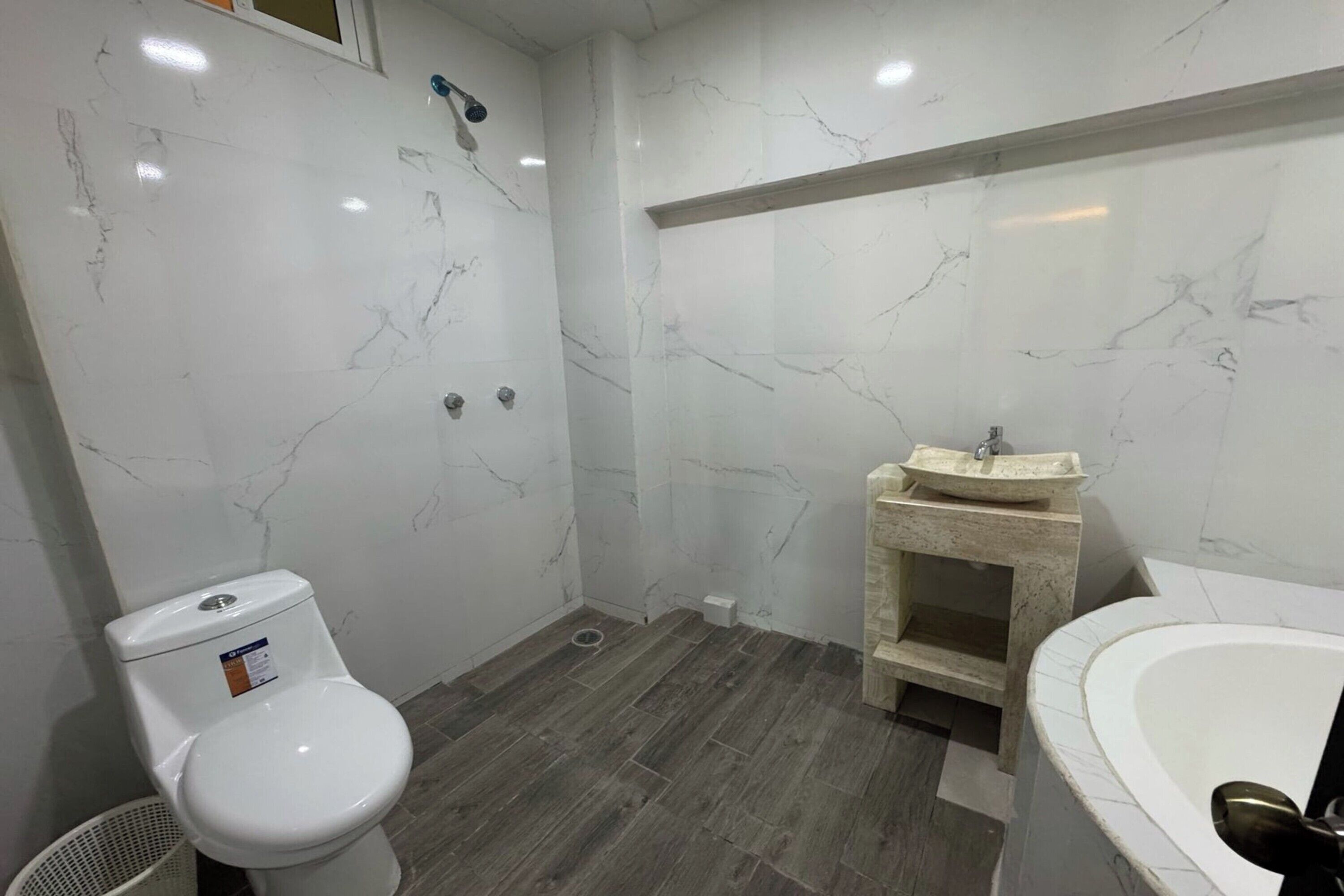 Un baño con inodoro, lavamanos y bañera.