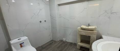 Un baño con inodoro, lavamanos y bañera.