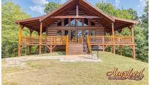 A wooden cabin with a porch, multiple windows, and a covered deck area. - Halfway to Heaven is perfect for a couples retreat or family getaway (Sevierville)
