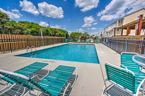 A swimming pool with lounge chairs and a no diving sign.