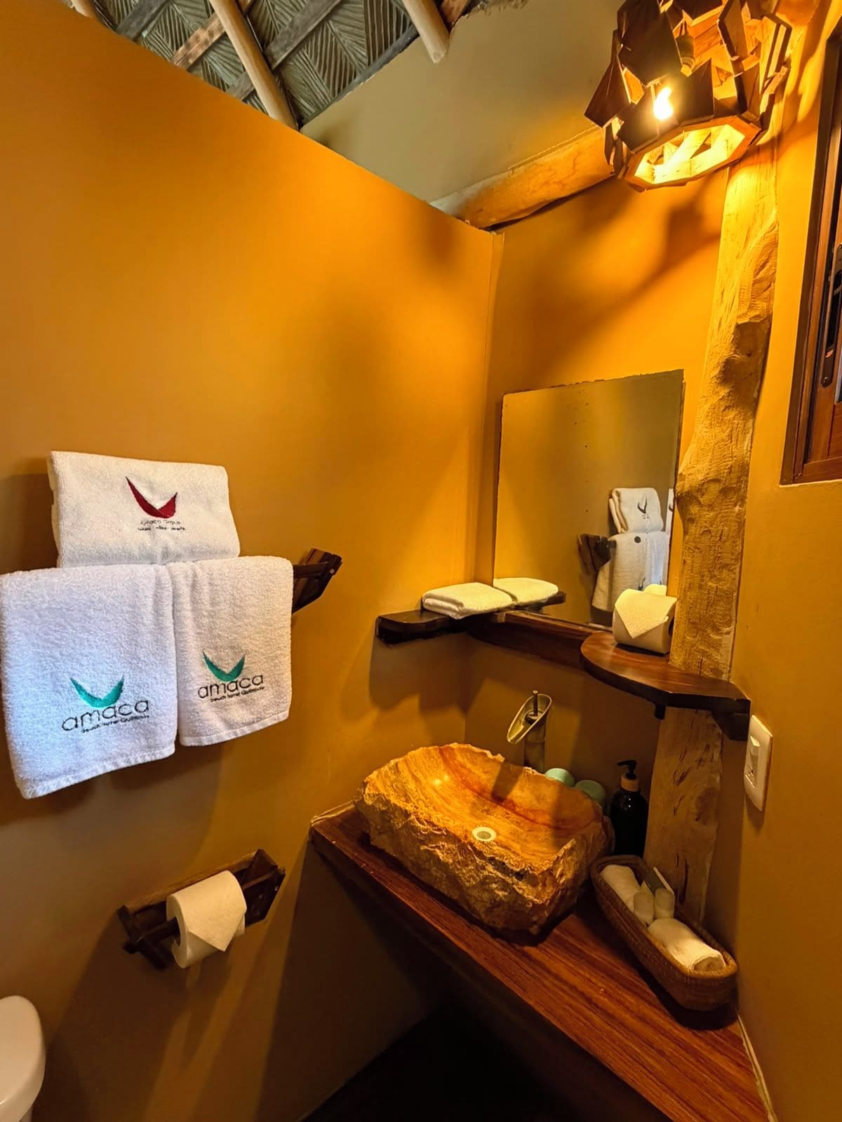 A bathroom with a wooden vanity, a sink, a mirror, and two towels hanging on the wall.