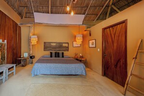 A room with a bed, bedside tables, a wooden door, and a ladder. - Amaca Beach Retreat - Puerto Vallarta South Shore (Quimixto)
