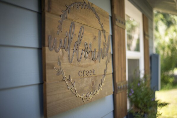 A wooden sign with the text "welcome creek" and decorative elements.
