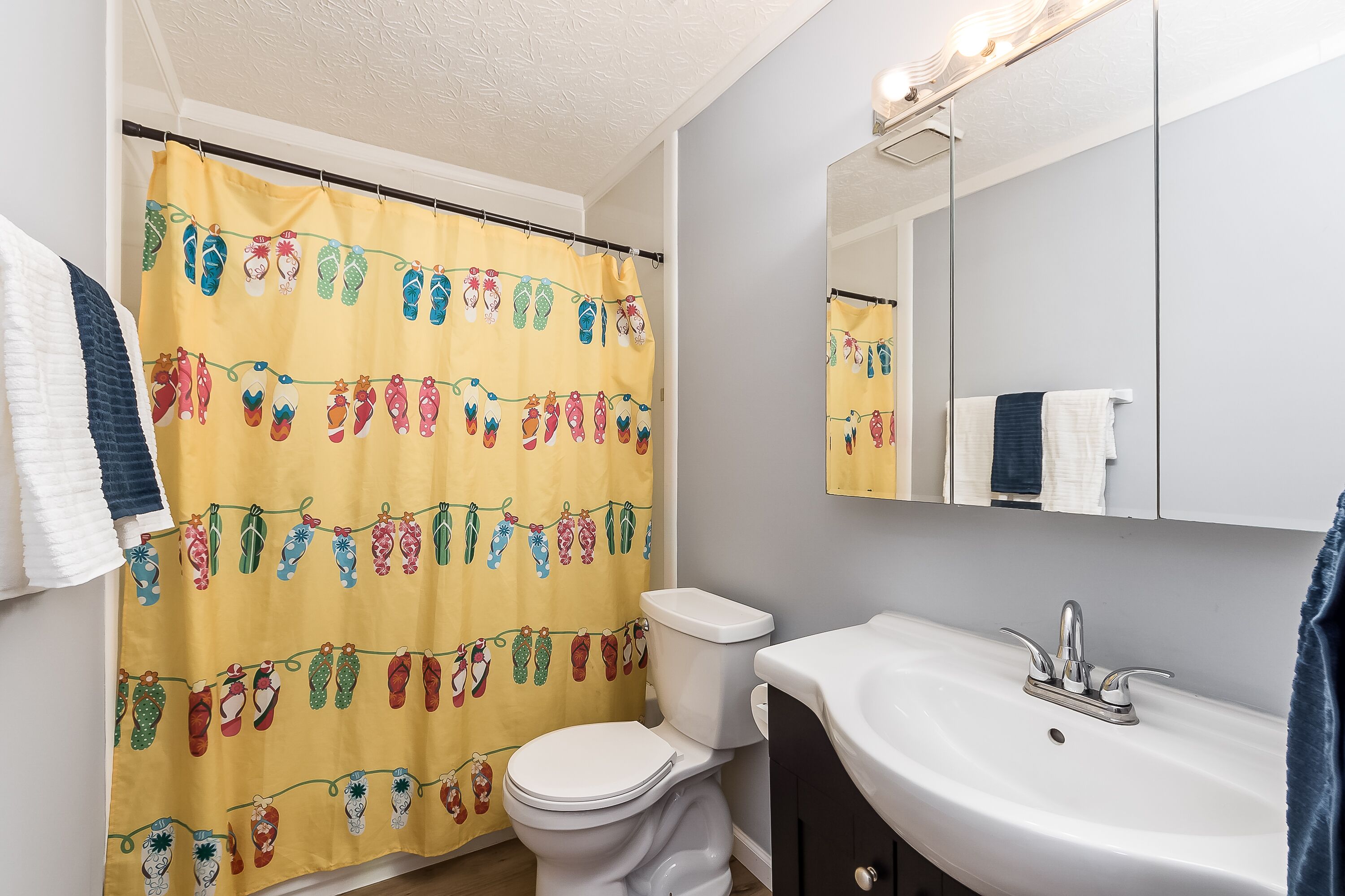 A bathroom with a toilet, sink, and mirror.