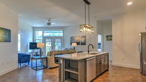 Una cucina moderna con isola centrale, elettrodomestici in acciaio inossidabile e una lampada a sospensione.