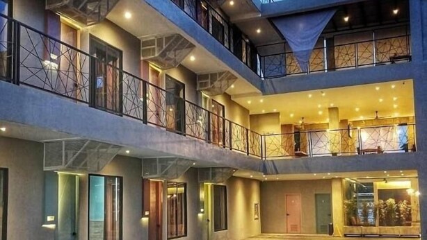 Un edificio de varios pisos con piscina, balcones y un interior bien iluminado.
