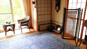 A traditional Japanese room with tatami flooring, a shoji screen, and a low table with a cushion. - PittINN Farm Keyaki (Inakadate-mura)