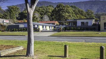 A motel with a red-tiled roof, a signboard, and a parking area.