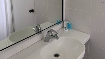 A bathroom with a white sink, a mirror, and a shower curtain.