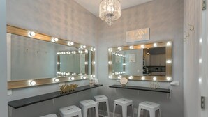 A vanity area with two large mirrors, lighted vanity lights, and white stools. - BNA Blue Retreat, Game Room, Hot Tub (Nashville)