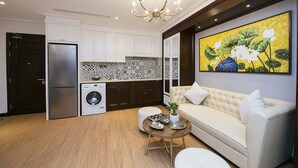 Una cocina moderna con lavadora, un comedor con sofá y un cuadro grande en la pared.