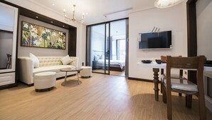 Una sala de estar moderna con sofá, reposapiés y mesa de comedor.