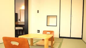 A room with tatami mat flooring, a wooden table, two wooden chairs, a small shelf with a mirror, and a sliding door. - Hotel Livemax BUDGET Namba (Osaka)