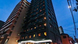 A multi-story hotel with a prominent sign for 'HOTEL LIVEMAX' at the ground level.
