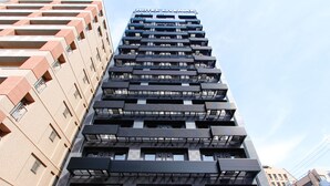 A multi-story hotel with a modern design, featuring balconies and a prominent "HOTEL L'VEMAX" sign.