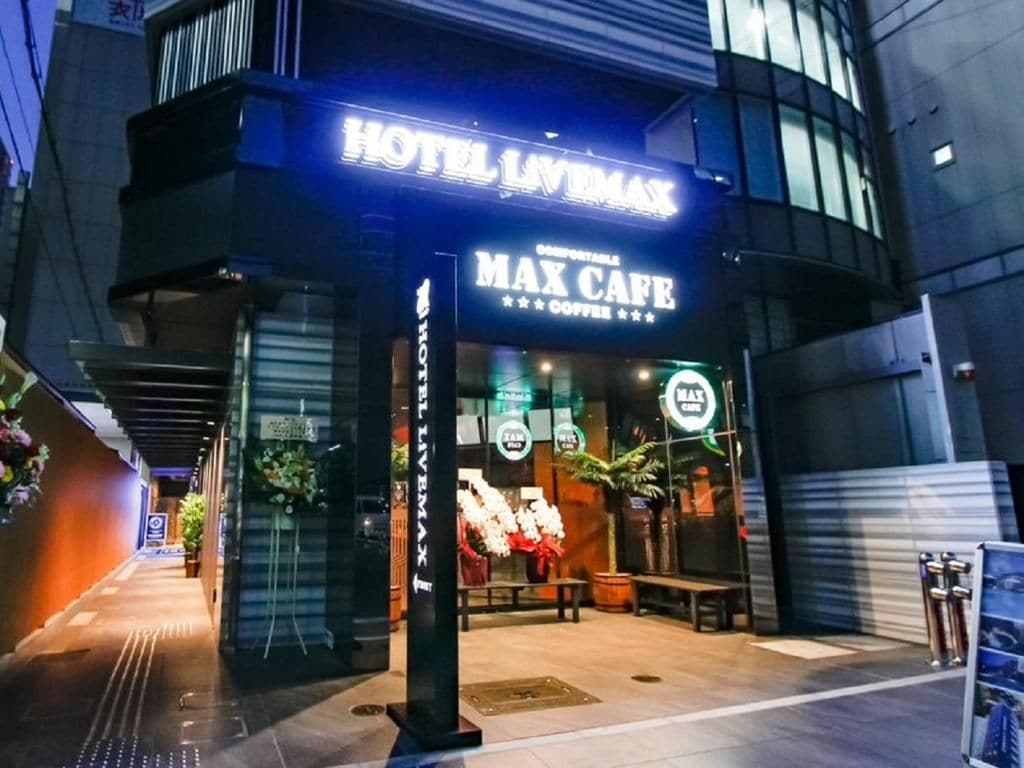 Un bâtiment arborant une enseigne indiquant « HÔTEL LAVIMAX » et « MAX CAFÉ », avec une architecture moderne et une entrée bien visible.